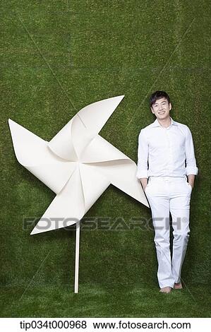 Stock Photo - A man sitting with a white pinwheel. Fotosearch