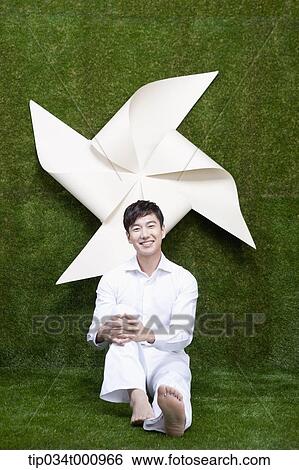 A man sitting with a white pinwheel View Large Photo Image Stock Photograph - A man sitting with a white pinwheel. Fotosearch
