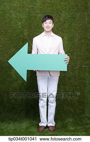 A man standing with a green arrow View Large Photo Image Stock Image - A man standing with a green arrow. Fotosearch