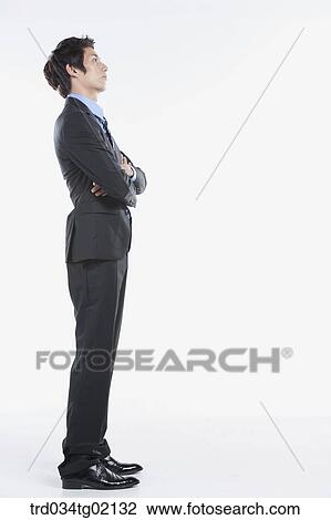 Stock Image - A man standing with his arms crossed. Fotosearch