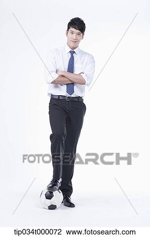 Stock Image - A man stepping on a soccer ball. Fotosearch