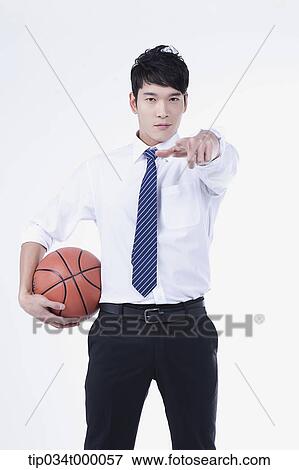 Stock Photo - A man stretching his hand with a basketball. Fotosearch
