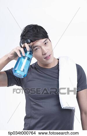 Picture - A man with a bottle of water and a towel. Fotosearch