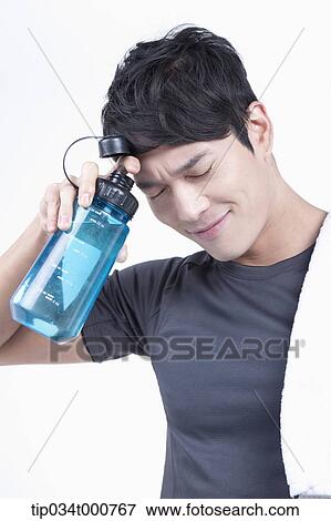 Stock Photo - A man with a bottle of water and a towel. Fotosearch