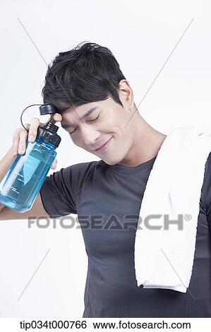 Stock Photograph - A man with a bottle of water and a towel. Fotosearch