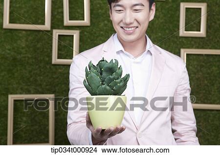 A man with a green cactus pot View Large Photo Image Picture - A man with a green cactus pot. Fotosearch