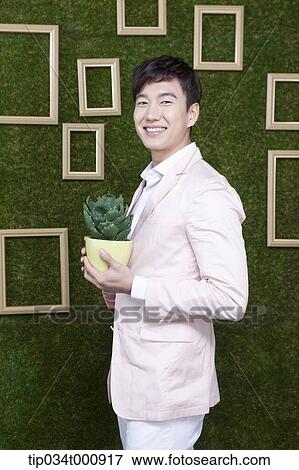 A man with a green cactus pot View Large Photo Image Stock Photo - A man with a green cactus pot. Fotosearch