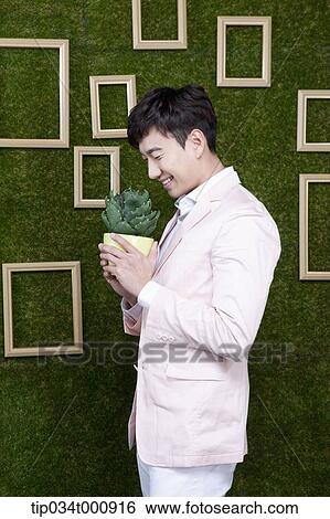 A man with a green cactus pot View Large Photo Image Stock Photograph - A man with a green cactus pot. Fotosearch