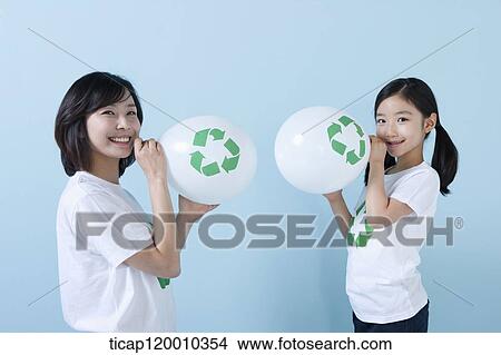 A mother and daughter blowing recycling balloons View Large Photo Image Picture - A mother and daughter blowing recycling balloons. Fotosearch