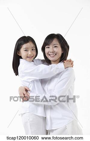 Stock Image - A mother and daughter hugging together. Fotosearch