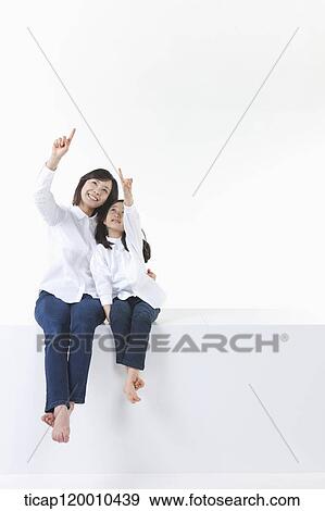 A mother and daughter pointing to the sky View Large Photo Image Stock Photo - A mother and daughter pointing to the sky . Fotosearch