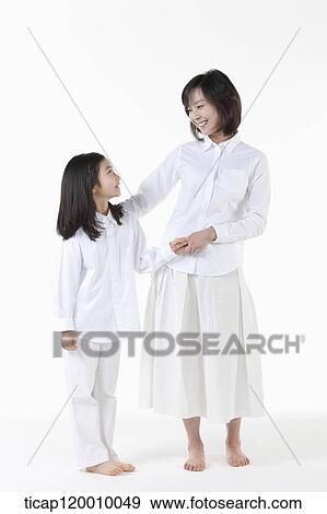 Stock Photo - A mother and daughter smiling at each other. Fotosearch