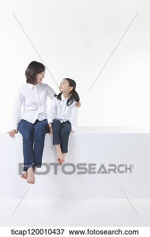 A mother and daughter smiling at each other View Large Photo Image Stock Photo - A mother and daughter smiling at each other. Fotosearch