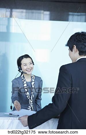 Stock Photography - A receptionist guiding a businessman . Fotosearch