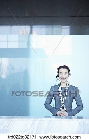 Stock Image - A receptionist putting on the headphone. Fotosearch