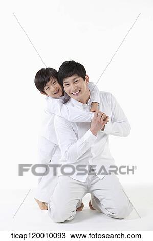 Stock Image - A son hugging his father from the back. Fotosearch