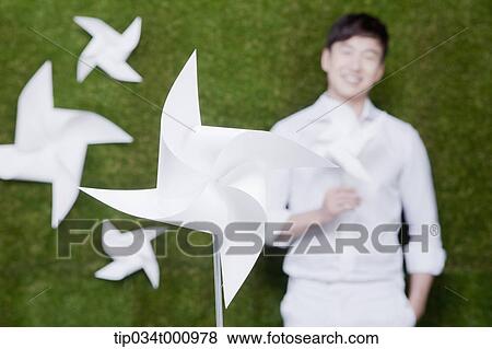 Stock Photo - A standing man and a white pinwheel. Fotosearch