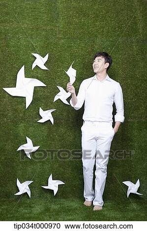 Stock Image - A standing man with white pinwheels. Fotosearch