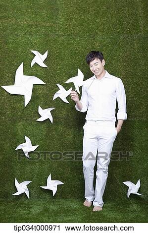 Stock Image - A standing man with white pinwheels. Fotosearch