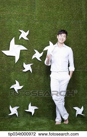 Stock Image - A standing man with white pinwheels. Fotosearch