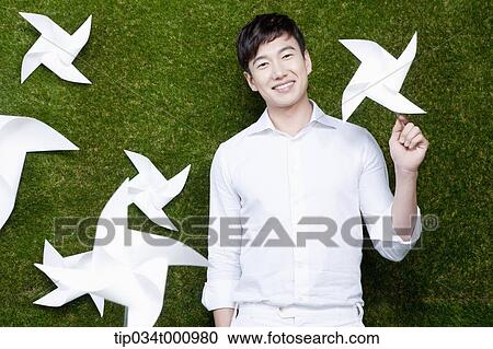 Stock Image - A standing man with white pinwheels. Fotosearch