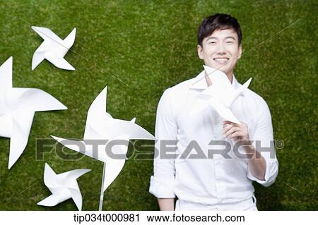 Stock Image - A standing man with white pinwheels. Fotosearch
