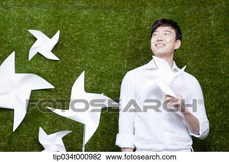 A standing man with white pinwheels View Large Photo Image Stock Image - A standing man with white pinwheels. Fotosearch