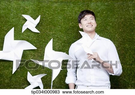 A standing man with white pinwheels View Large Photo Image Stock Image - A standing man with white pinwheels. Fotosearch