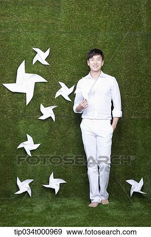 Stock Photo - A standing man with white pinwheels. Fotosearch