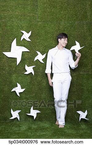 Stock Photograph - A standing man with white pinwheels. Fotosearch