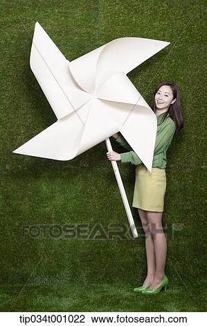 A standing woman with a big white pinwheel View Large Photo Image Stock Image - A standing woman with a big white pinwheel. Fotosearch