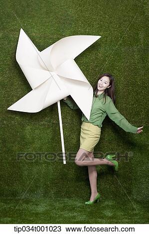 A standing woman with a big white pinwheel View Large Photo Image Stock Image - A standing woman with a big white pinwheel. Fotosearch