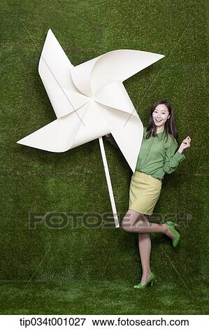 A standing woman with a big white pinwheel View Large Photo Image Stock Photo - A standing woman with a big white pinwheel. Fotosearch