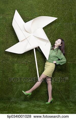 A standing woman with a big white pinwheel View Large Photo Image Stock Photo - A standing woman with a big white pinwheel. Fotosearch