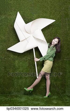 A standing woman with a big white pinwheel View Large Photo Image Stock Photography - A standing woman with a big white pinwheel. Fotosearch