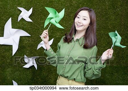 A standing woman with green and white pinwheels View Large Photo Image Picture - A standing woman with green and white pinwheels. Fotosearch