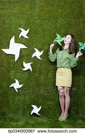 Stock Photo - A standing woman with green and white pinwheels. Fotosearch