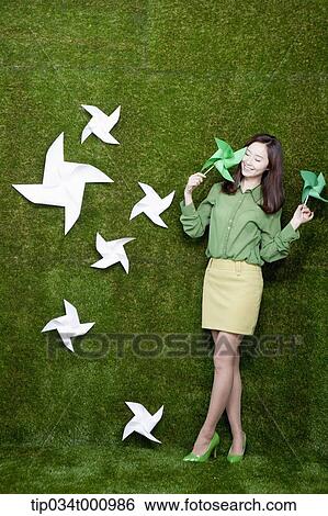 A standing woman with green and white pinwheels View Large Photo Image Stock Photograph - A standing woman with green and white pinwheels. Fotosearch