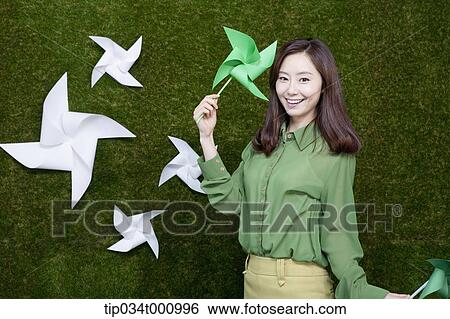 Stock Photograph - A standing woman with green and white pinwheels. Fotosearch