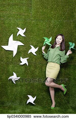Stock Photography - A standing woman with green and white pinwheels. Fotosearch