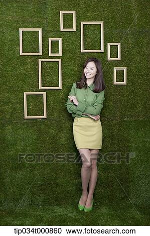 A woman and wooden frames on the green wall View Large Photo Image Stock Image - A woman and wooden frames on the green wall. Fotosearch
