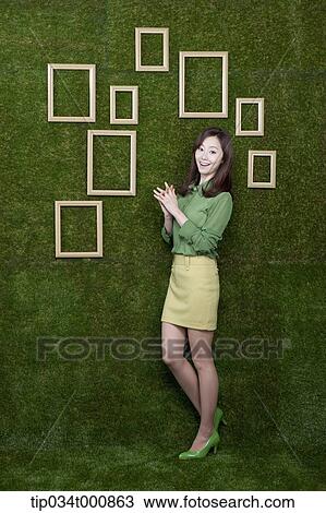 A woman and wooden frames on the green wall View Large Photo Image Stock Image - A woman and wooden frames on the green wall. Fotosearch