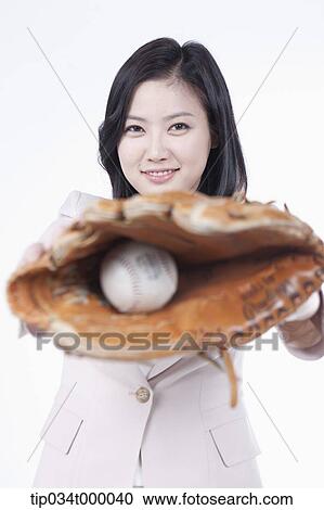 Stock Image - A woman catching a baseball with a glove. Fotosearch