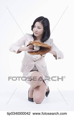 Stock Image - A woman catching a baseball with a glove. Fotosearch