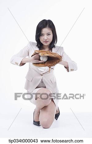 Stock Image - A woman catching a baseball with a glove. Fotosearch