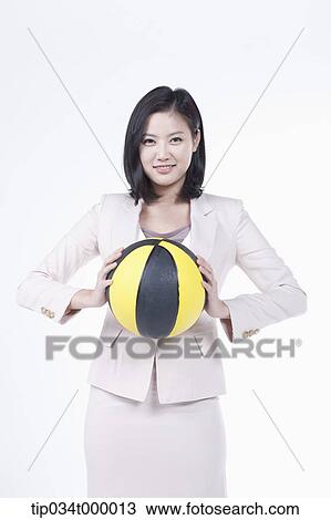 Stock Image - A woman holding the basketball. Fotosearch