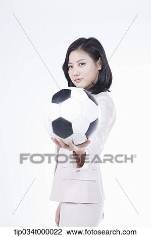Stock Image - A woman holding the soccer ball. Fotosearch