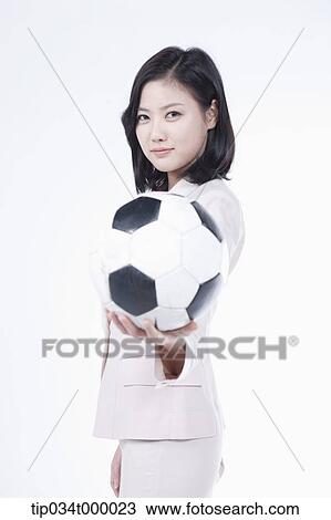 Stock Image - A woman holding the soccer ball. Fotosearch