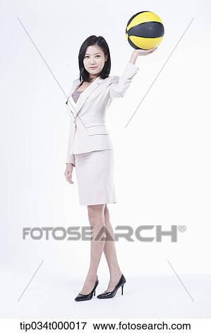 Stock Photo - A woman holding up the basketball. Fotosearch
