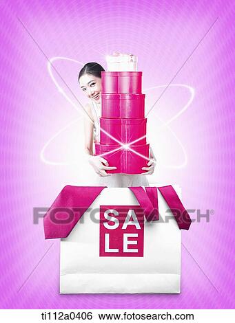 A woman holding up the gift from the sale bag View Large Photo Image Stock Photograph - A woman holding up the gift from the sale bag. Fotosearch